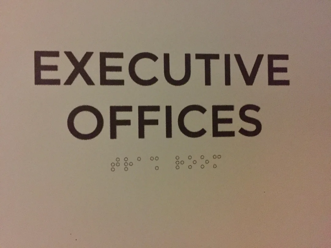 The braille on the "Executive Offices" sign outside where I work is both flat and says "Trash Room"
